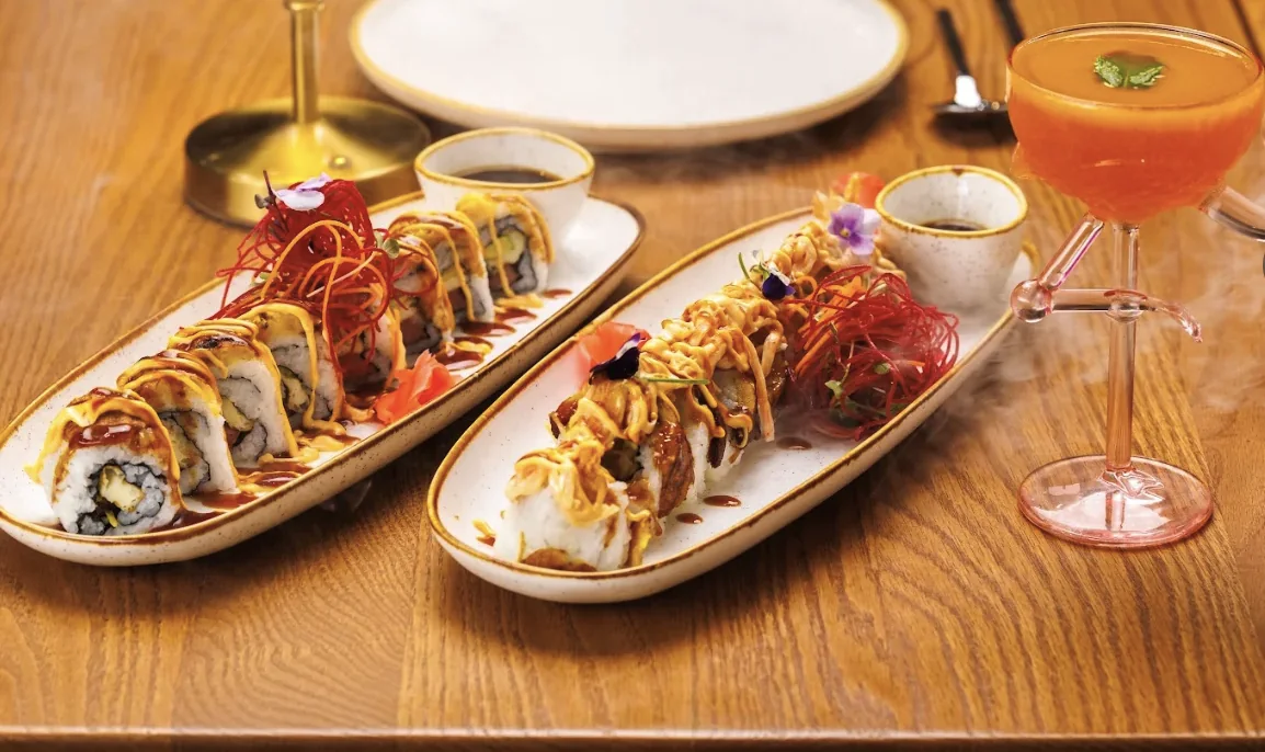 Two Casa Lum sushi rolls with crispy threads and edible flowers